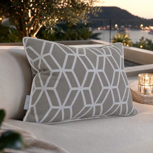 Designer Outdoor-Kissen Crystal Gold von chillisy® in Hellgrau mit weißem geometrischem Muster auf einer exklusiven Lounge am Meer.