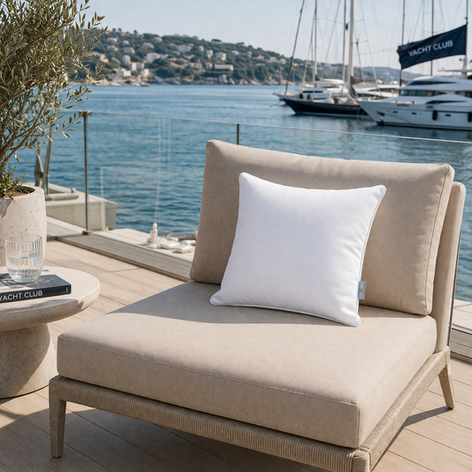 Weißes Gartenkissen witterungsbeständig von chillisy auf beigem Gartenstuhl im Yachtclub am Meer - hergestellt in Deutschland.