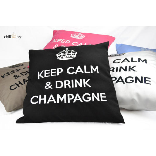 Ein Haufen von Dekokissen mit Krone und Aufschrift KEEP CALM & DRINK CHAMPAGNE in den Farben Taupe, Pink, Hellgrau und Schwarz.