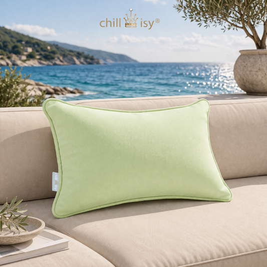Gartenkissen rechteckig in Lindgrün von chillisy hergestellt in Deutschland auf Gartenlounge mit Meer und Küste im Hintergrund.