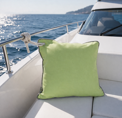 Grünes Bootskissen mit rostfreier Öse zum Befestigen am Boot oder Yacht dargestellt auf dem Deck einer weißen Motoryacht auf dem Meer. chillisy Kissen hergestellt in Deutschland.