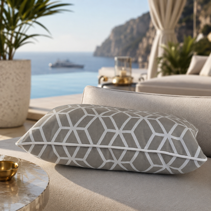 Designer Outdoor-Kissen Crystal Gold von chillisy® in Hellgrau mit weißem geometrischem Muster auf einer exklusiven Lounge mit Infinity-Pool und Meerblick.