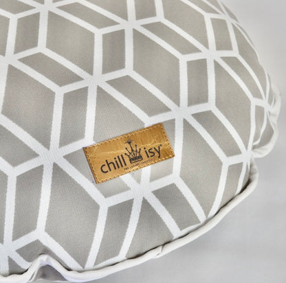 Detailansicht des Designer-Rundkissens Crystal Gold von chillisy® in Hellgrau mit Goldlabel, weißem geometrischem Muster und weißem Keder.