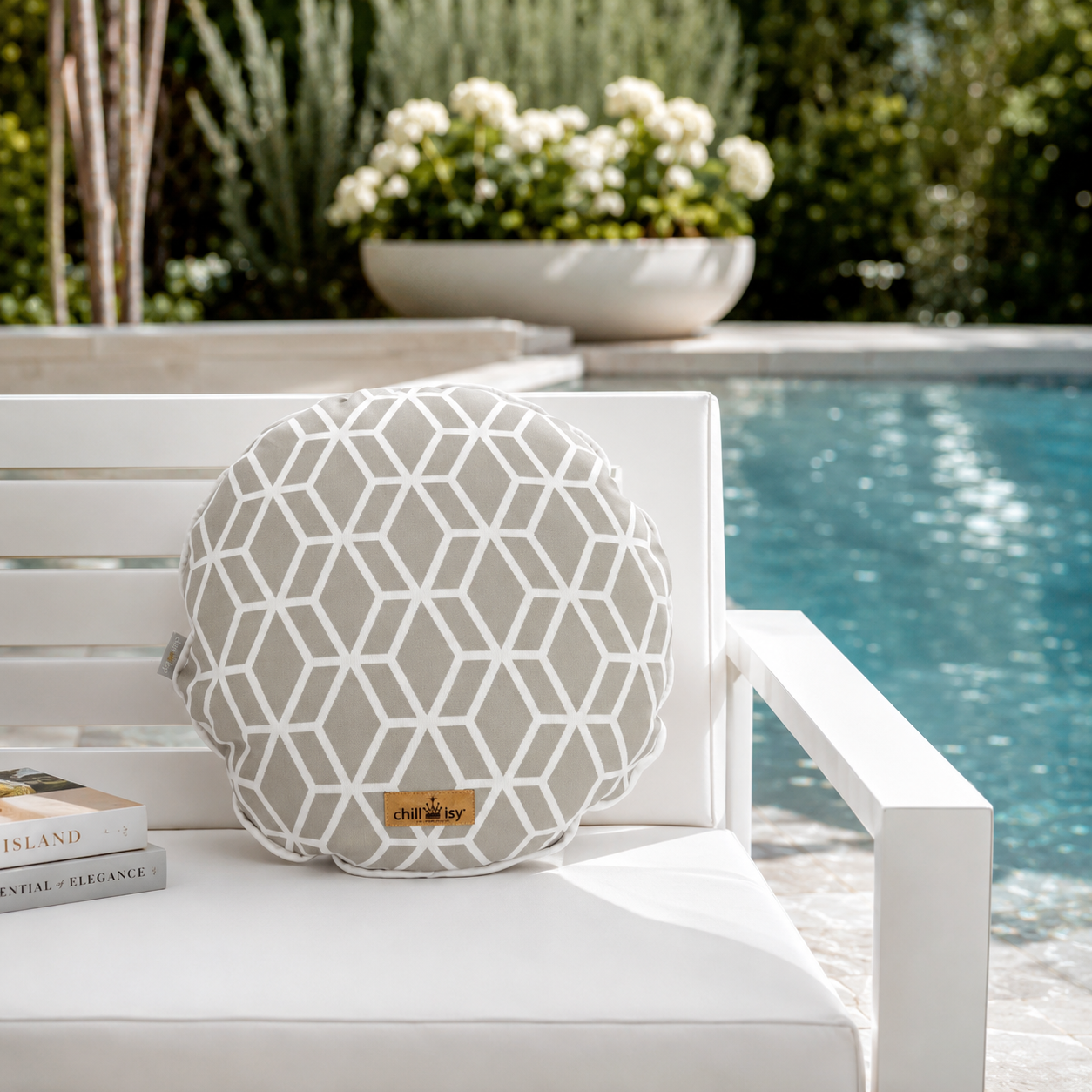 Designer-Rundkissen Crystal Gold von chillisy® in Hellgrau mit weißem geometrischem Muster auf einem weißen Outdoor-Loungesessel am Pool.