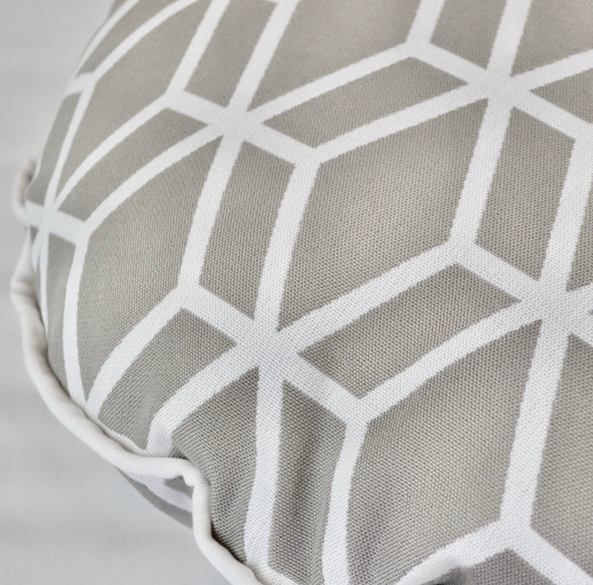Detailansicht des Designer-Rundkissens Crystal Gold von chillisy® in Hellgrau mit weißem geometrischem Muster und hochwertiger Stoffstruktur.