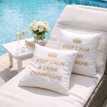 Weiße chillisy Outdoor-Kissen mit goldenem Stick „Keep Calm & Drink Champagne“ auf luxuriöser Terrasse mit Lounge und Poolblick