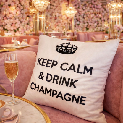 Wollweisses bzw. cremeweisses Dekokissen mit schwarzer Krone und Schriftzug KEEP CALM & DRINK CHAMPAGNE im blumigen Trendcafe