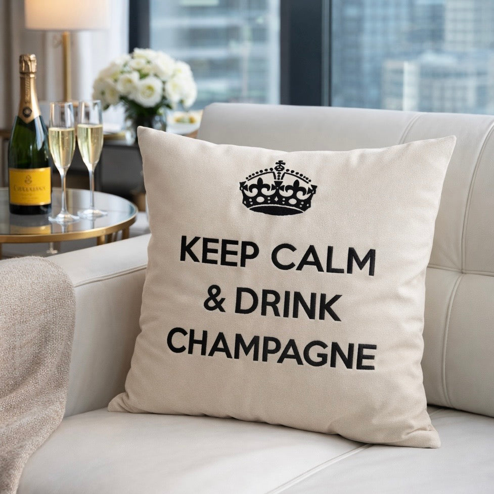 Wollweisses bzw. cremeweisses Dekokissen mit schwarzer Krone und Schriftzug KEEP CALM & DRINK CHAMPAGNE 