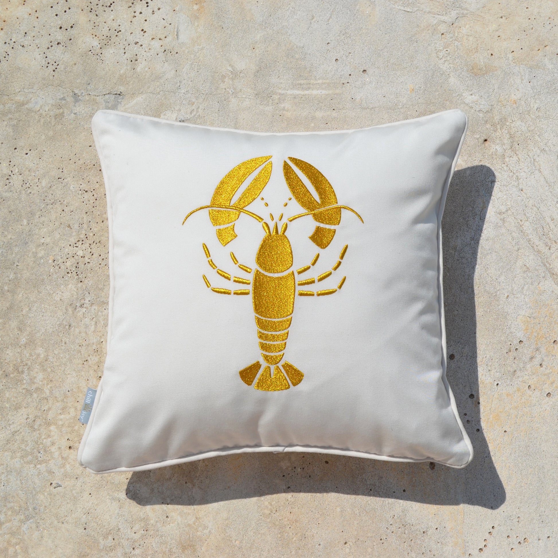 Weißes Kissen mit dem gold gestickten Motiv Lobster Hummer, Größe 45x45 cm, Verwendung im Innen- und Außenbereich. Marke: chillisy