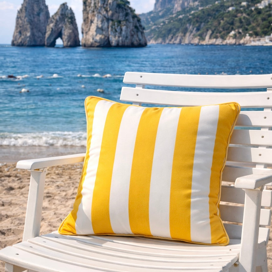 Outdoorkissen gelb weiss gestreift mit keder auf weißem Gartenstuhl am Strand