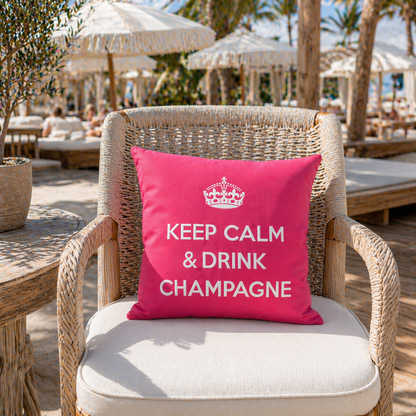 Dekokissen Pink/Weiß mit Krone und Schriftzug KEEP CALM & DRINK CHAMPAGNE auf Gartenstuhl im Beach Club präsentiert. Hergestellt von chillisy in Deutschland.