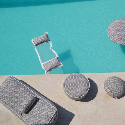Graue Crysral Gold Kollektion mit Daybed, Wasserhängematte, Badeinsel, Schwimmnudel, Pouf von chillisy mit geometrischem Muster schwebend auf kristallklarem türkisfarbenem Poolwasser – hochwertige Detailaufnahme für luxuriöse Entspannung im Pool. Made in Germany.