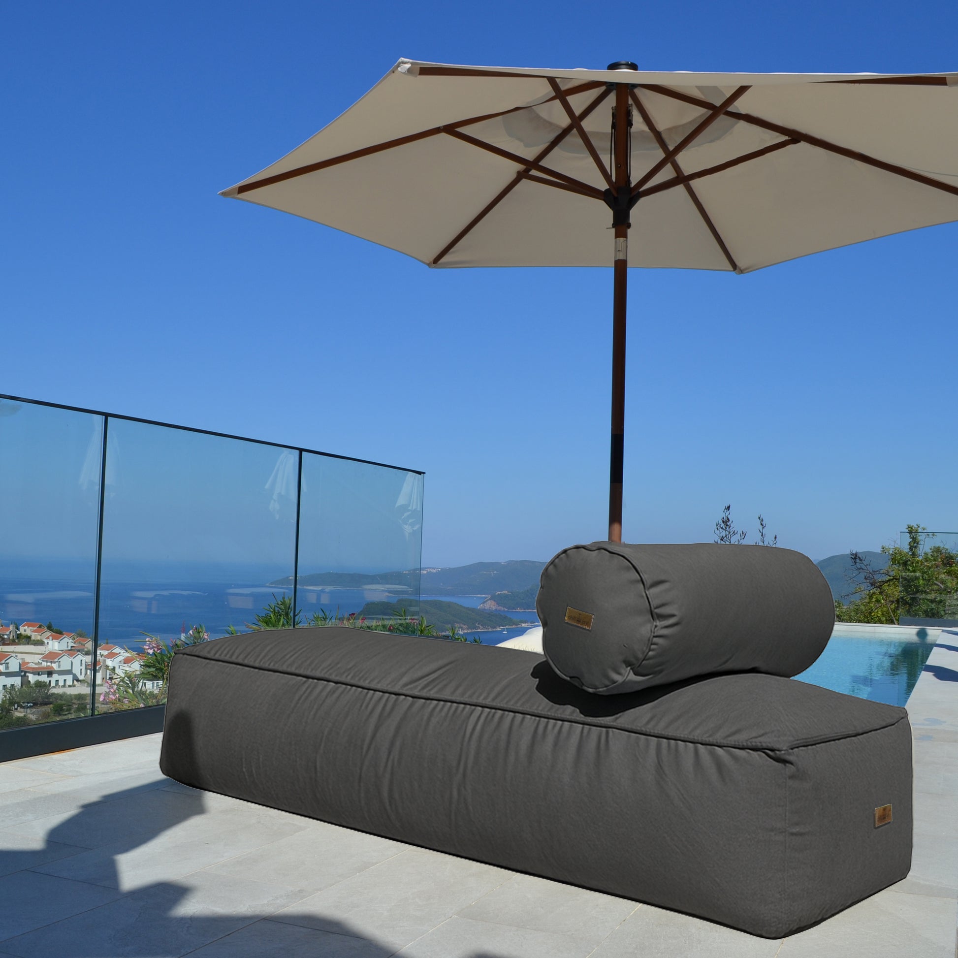 chillisy® Daybed in Anthrazit mit Nackenrolle auf luxuriöser Poolterrasse mit Meerblick