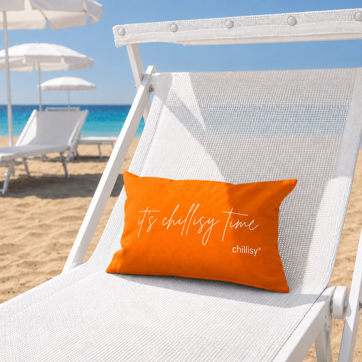 Orangenes chillisy Piccolino „it's chillisy time“ als Strand- und Reisekissen auf einer weißen Sonnenliege