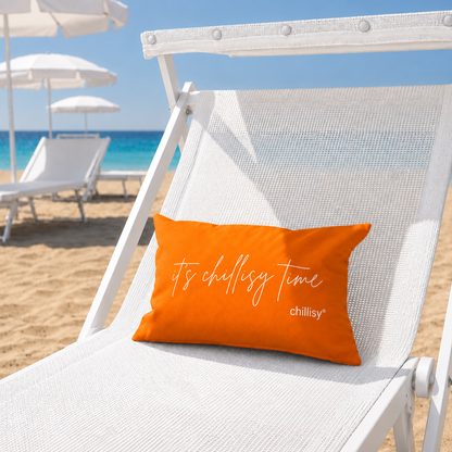Orangenes chillisy Piccolino „it's chillisy time“ als Strand- und Reisekissen auf einer weißen Sonnenliege