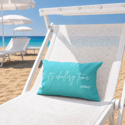 Türkises chillisy Piccolino „it's chillisy time“ als Strand- und Reisekissen auf einer weißen Sonnenliege