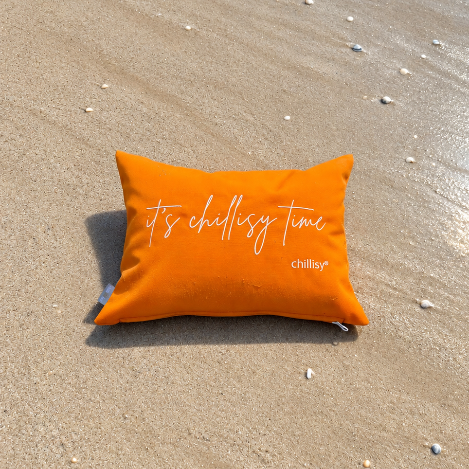 Oranges Piccolino Schwimmkissen von chillisy® am Strand direkt am Wasser
