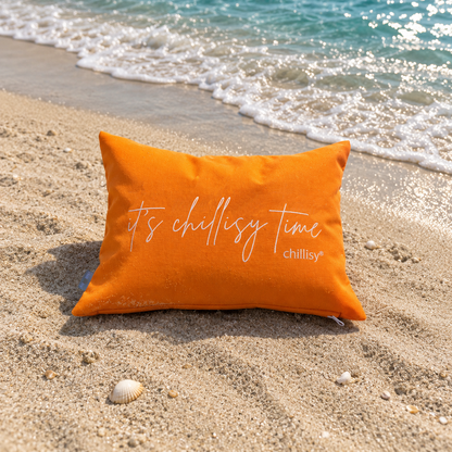Orange farbenes Piccolino Kissen am türkis farbenen Strand mit Schriftzug: it's chillisy time von chillisy.
