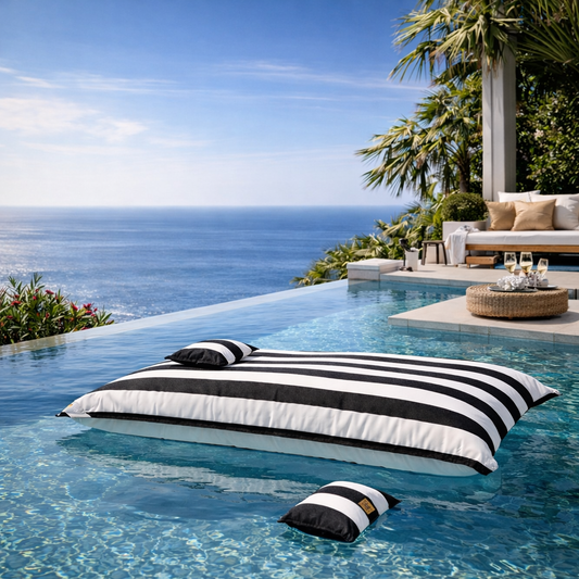 Schwarz weiß gestreifter Pool Sitzsack Lungo von chillisy auf dem Wasser schwebend mit Piccolino Swimmkissen.