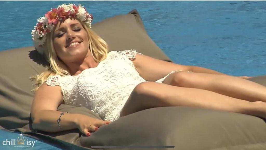 Frau im Kleid und mit Blumenkranz entspannt auf einem Pool Sitzssack von chillisy, hergestellt in Deutschland. 