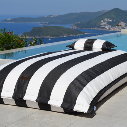Schwarz weiß gestreifter Pool Sitzsack Lungo von chillisy am Pool liegend.