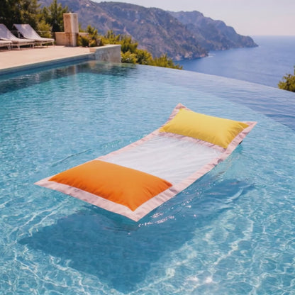 Wasserhängematte mit Netz in orange und gelb von chillisy im Pool mit Meerblick liegend.