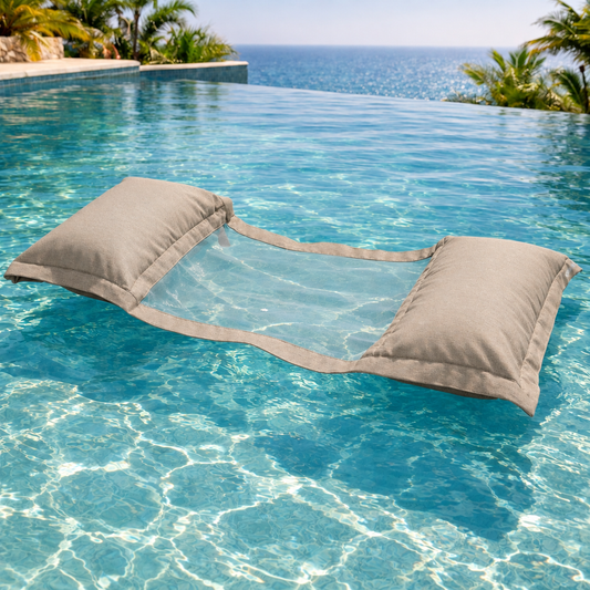chillisy® Wasserhängematte in Taupe 26 mit transparentem Netz, schwimmend in einem türkisblauen Infinity-Pool mit Meerblick.