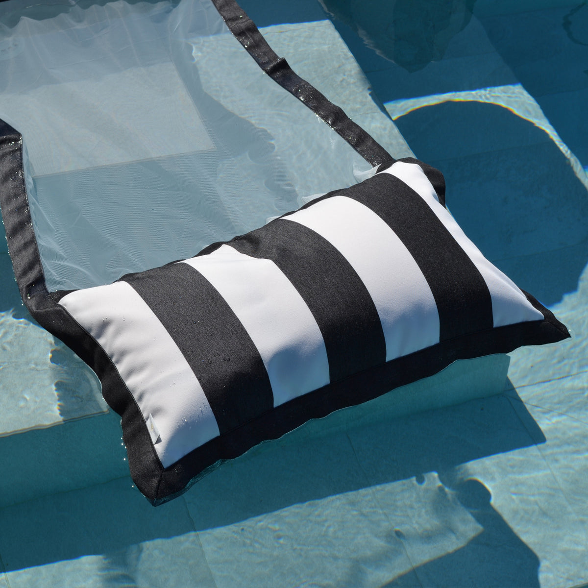 Schwarz weiß gestreifte Wasserhängematte im Pool schwebend der chillisy Sveti Stefan Kollektion, hergestellt in Deutschland.