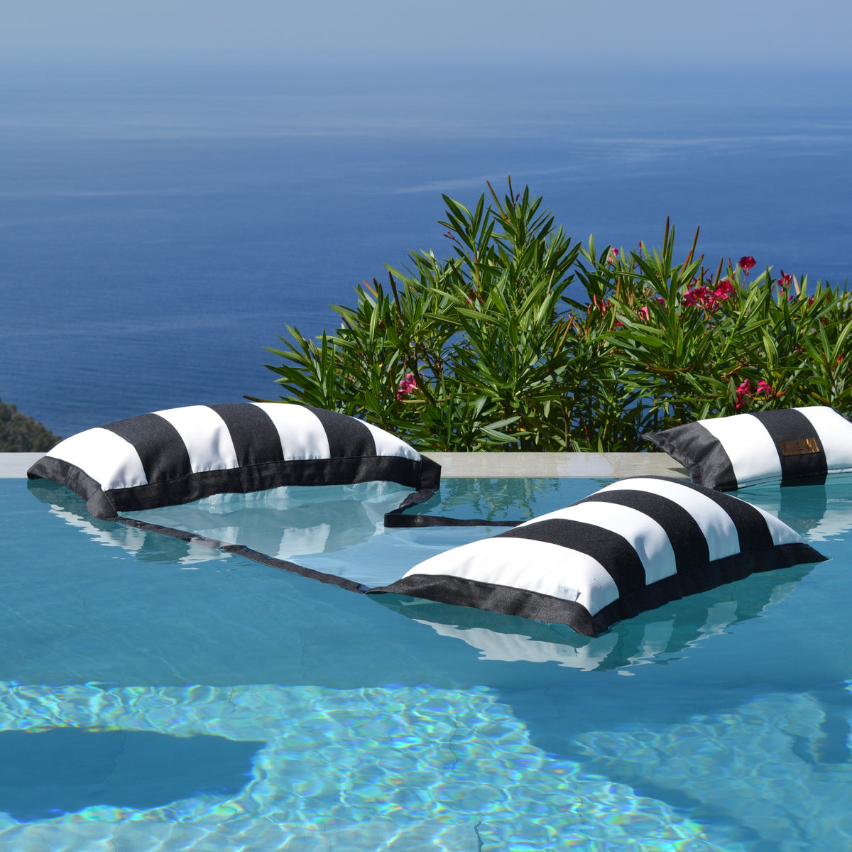 Schwarz weiß gestreifte Wasserhängematte im Pool schwebend der chillisy Sveti Stefan Kollektion, hergestellt in Deutschland.